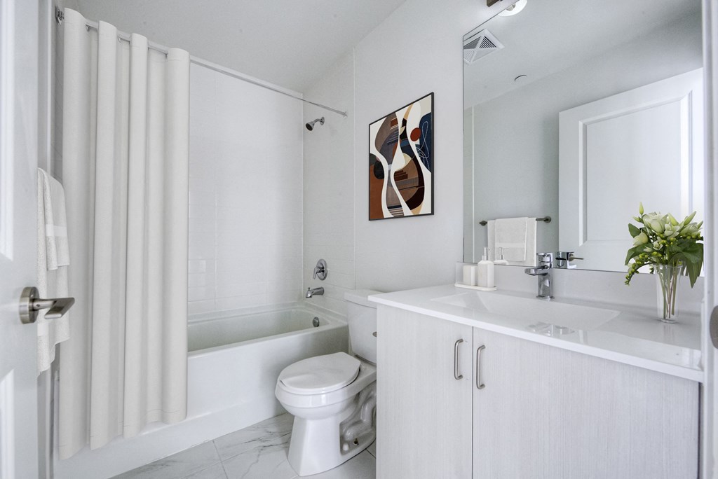 a white bathroom with a toilet and a tub and a sink