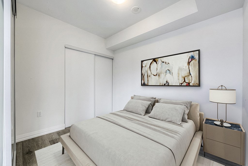 a bedroom with a bed and a painting on the wall