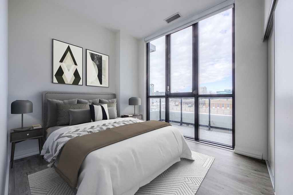 a bedroom with a bed and a large window