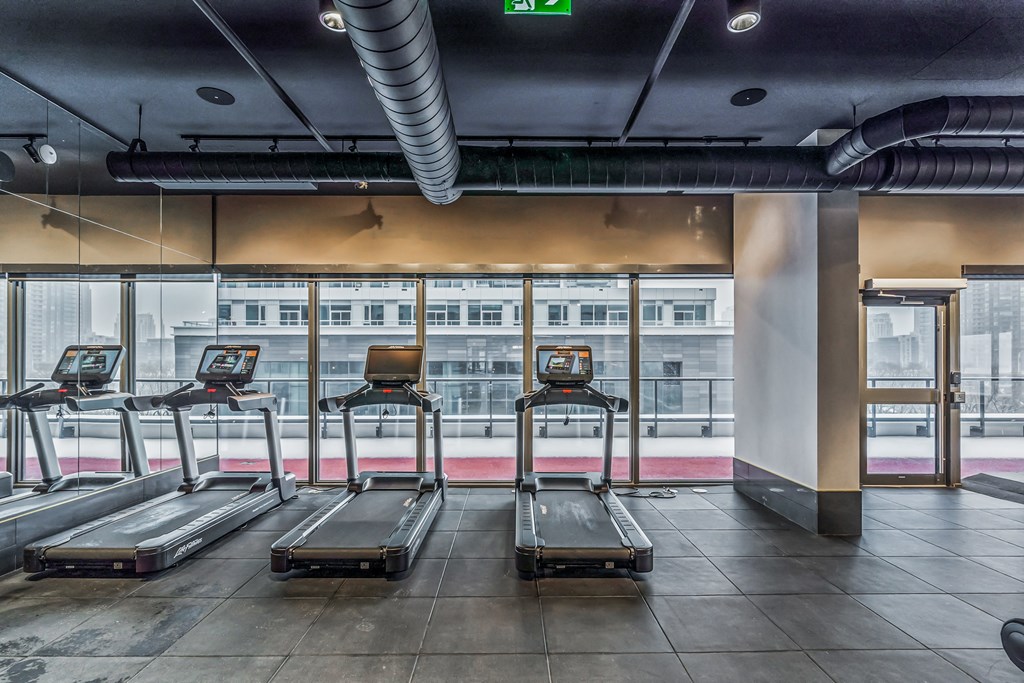 indoor fitness center with treadmills facing windows