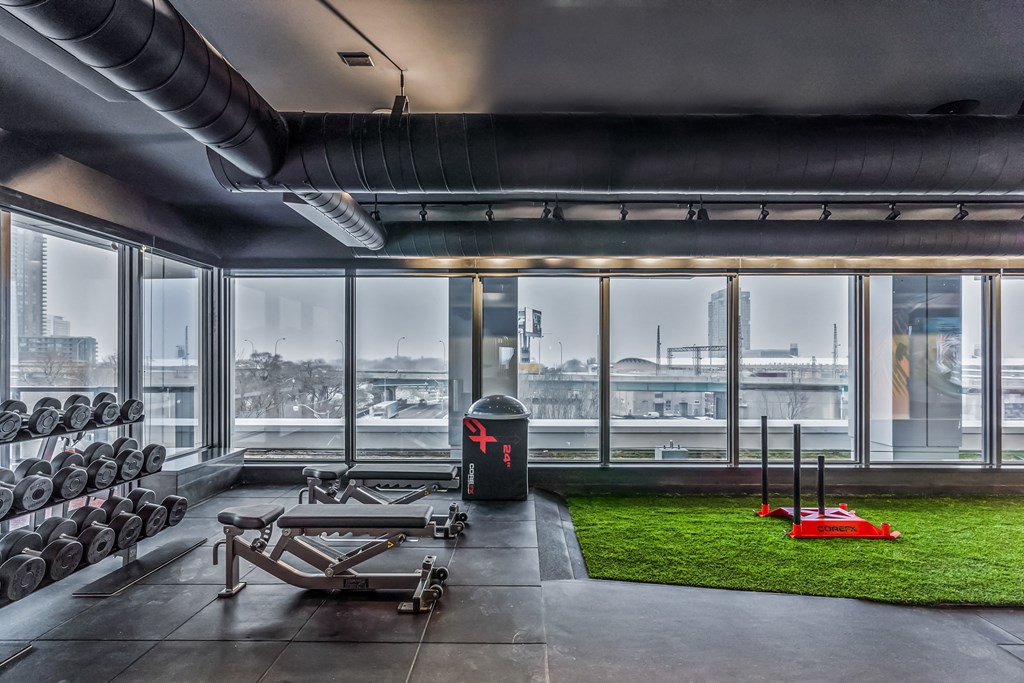 workout room with bench, dumbells and large windows