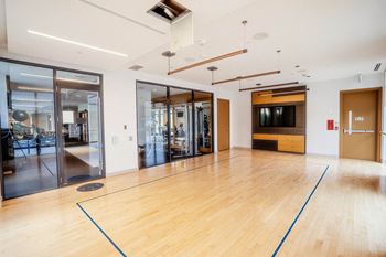 the ballroom has a hardwood floor and a large wall mounted tv