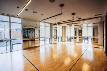 a large dance room with wood floors and large windows