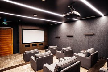 a large screening room with a projector screen and chairs