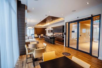 a large dining room with tables and chairs and a kitchen