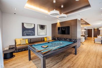 a living room with a pool table and a television