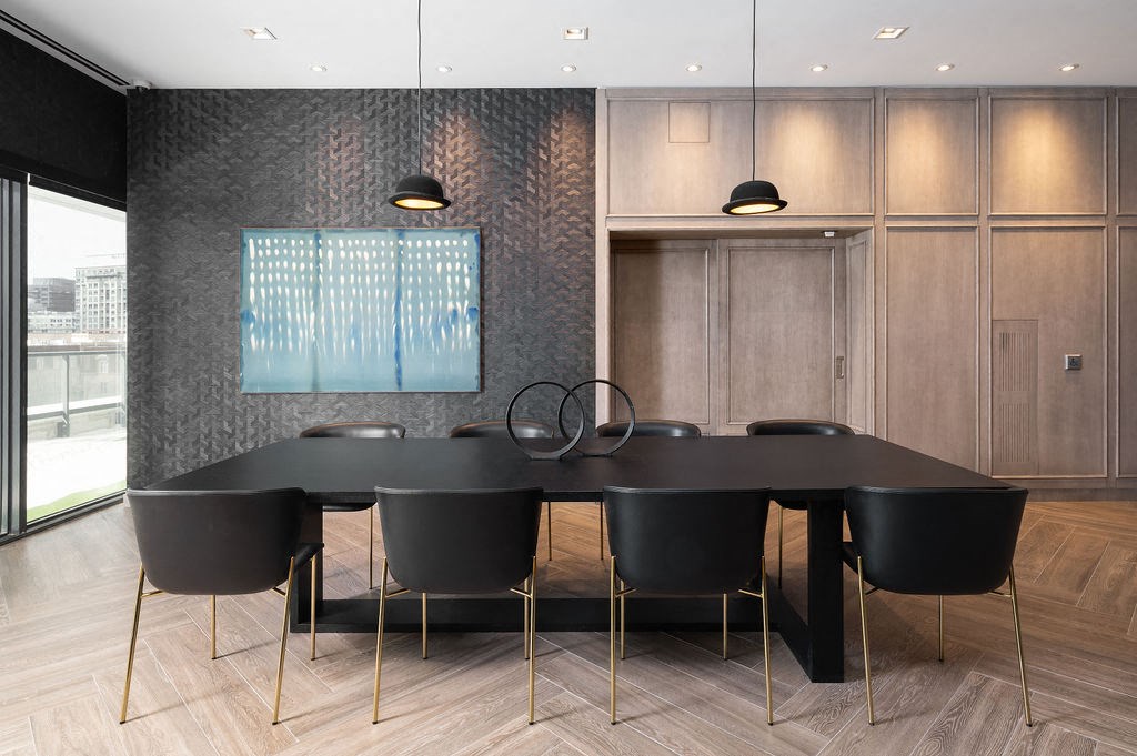 a dining room with a black table and chairs