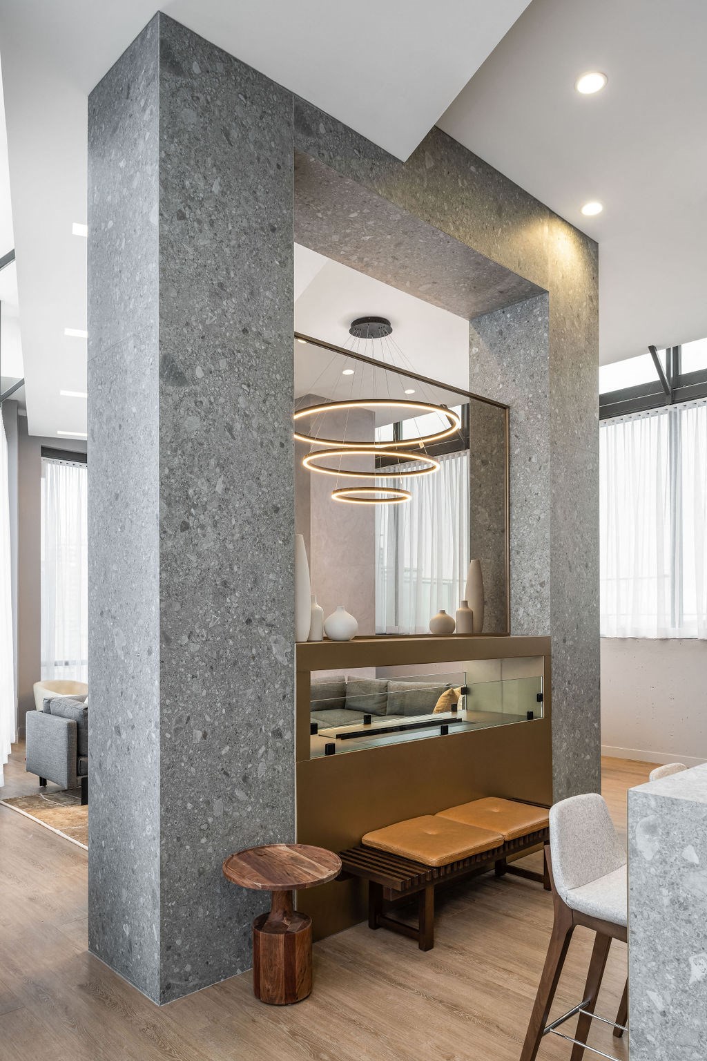 a large concrete pillar with a mirror and a bench in a room