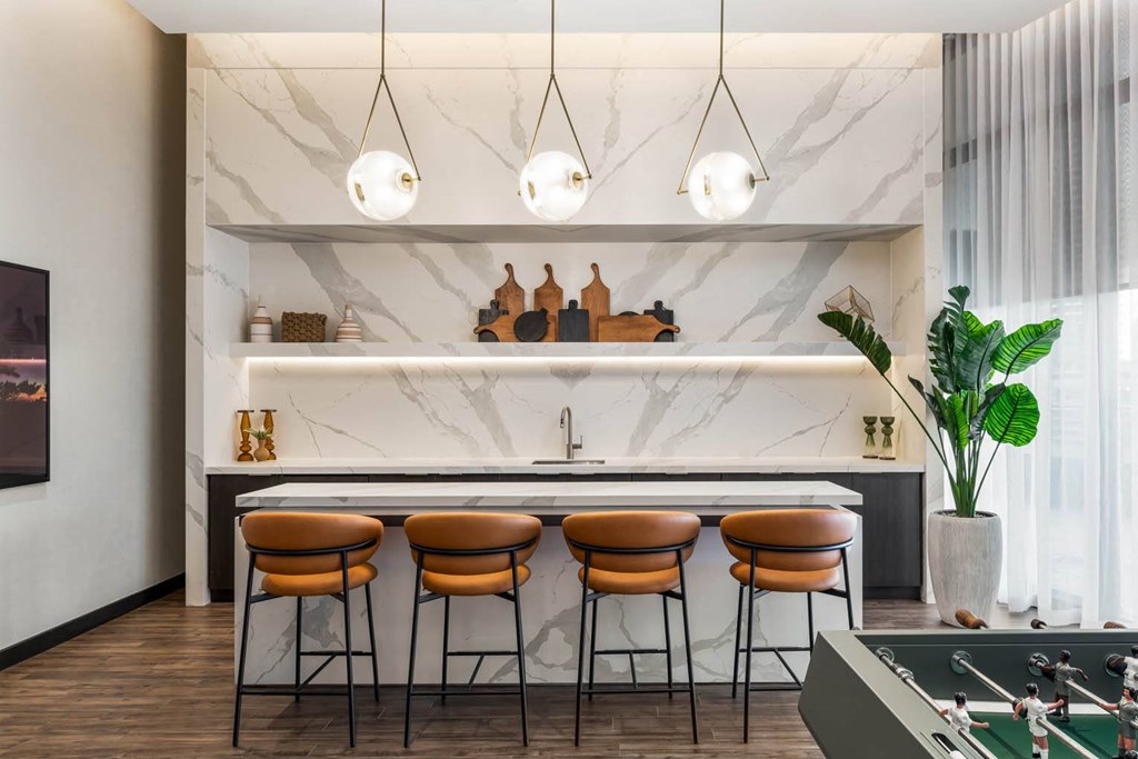 a bar with four stools in a room with a pool table