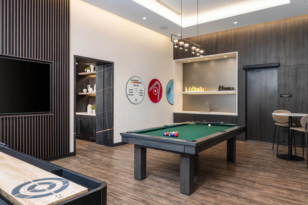 a games room with a pool table and a television