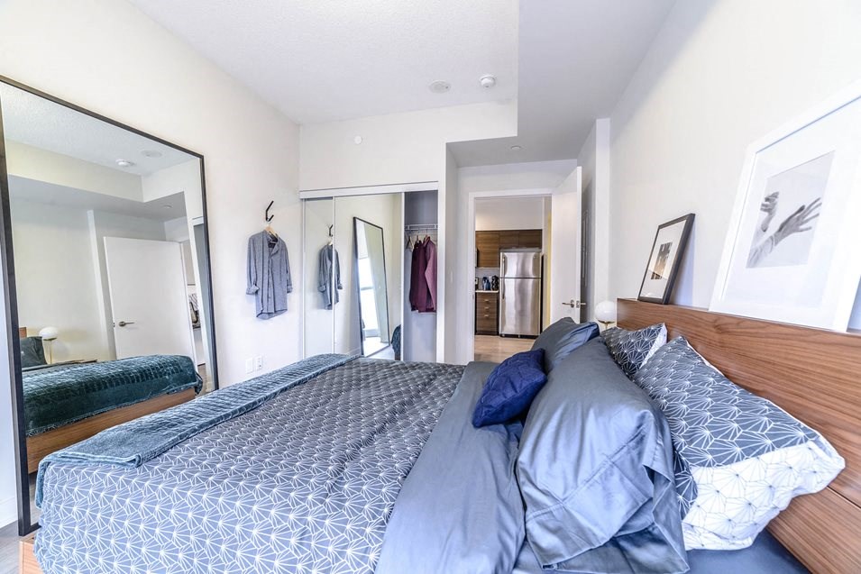 a bedroom with a large bed and a mirror