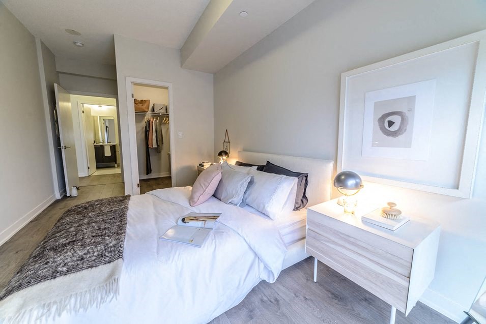 a bedroom with a white bed and a white dresser