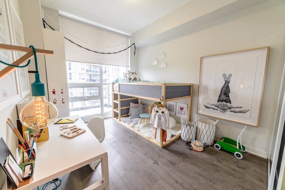 a bedroom with a crib and a desk and a window