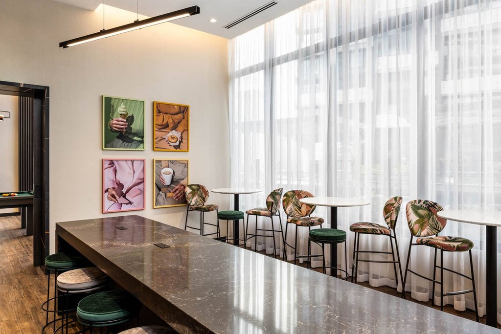 a long communal table and chairs in a room with large windows