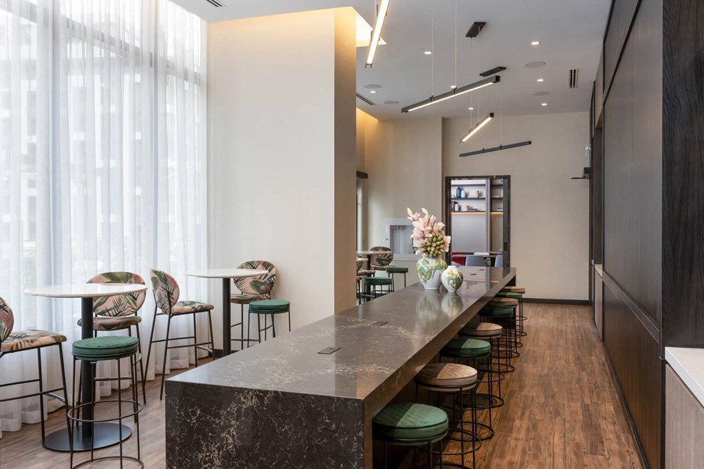 a long bar with chairs and tables in a lobby
