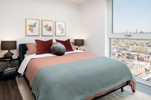 a bedroom with a bed and a large window