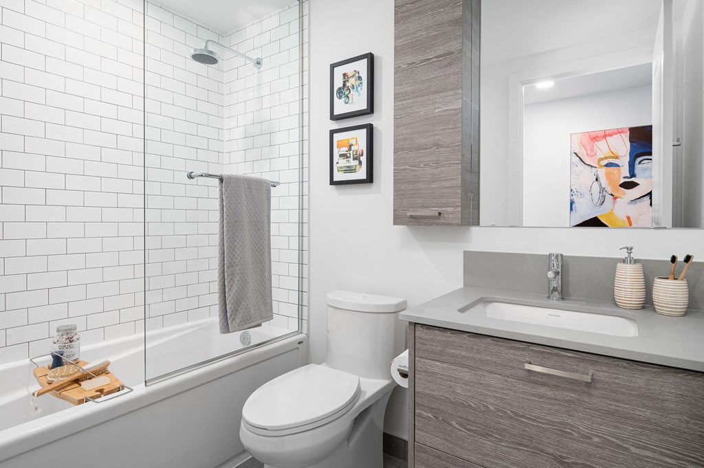 a bathroom with a toilet sink and shower and a mirror