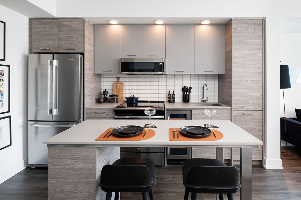a kitchen with a center island and a stainless steel refrigerator