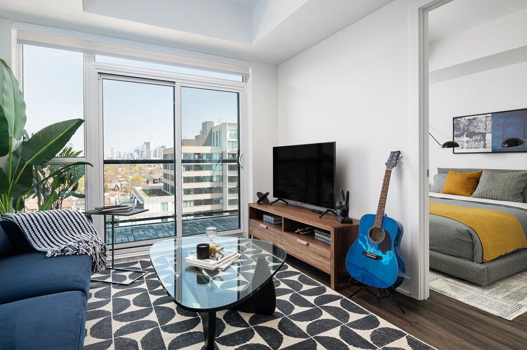 a living room with a blue couch and a guitar on the wall