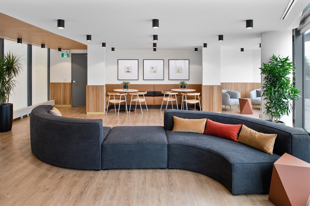 a living room with a blue couch and a table and chairs