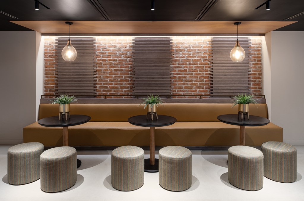 a seating area with stools and a brick wall