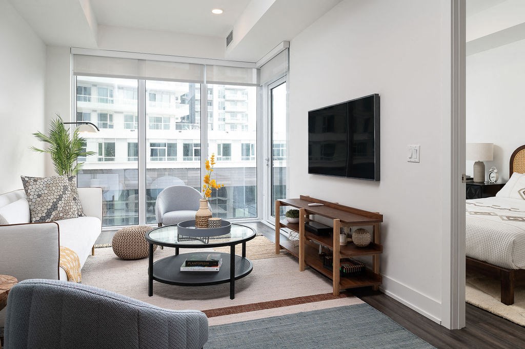 living room with couch, circular coffee table and mounted flatscreen tv