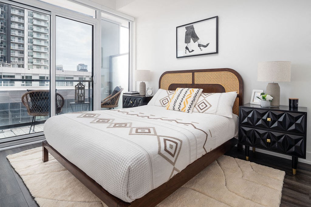 bed with balcony on the left side and views of downtown toronto