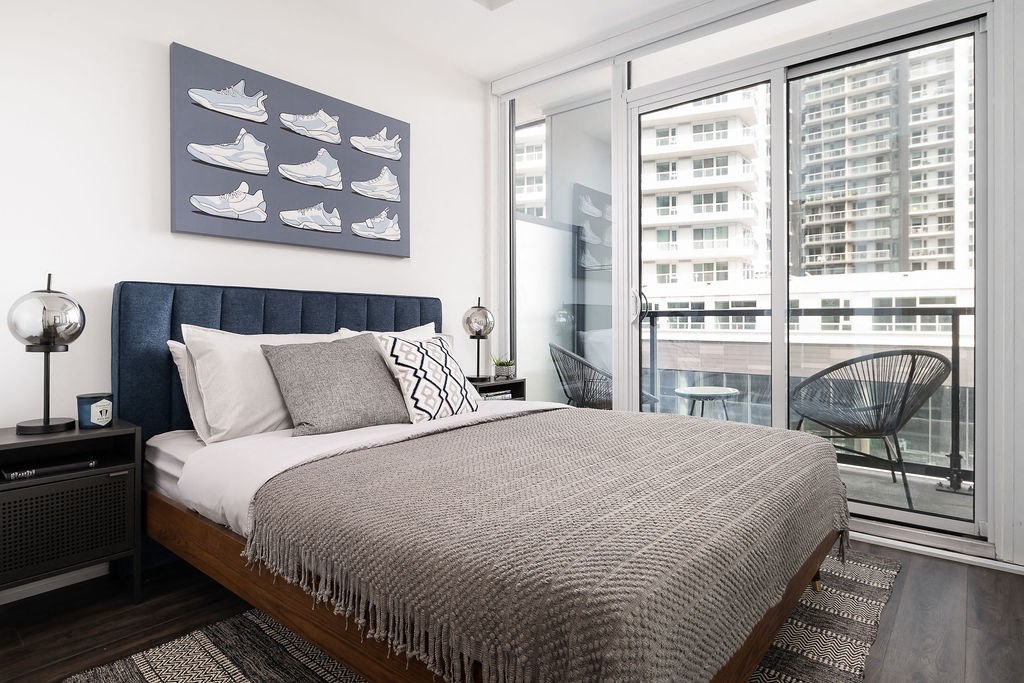 bed with modern art hanging above headboard