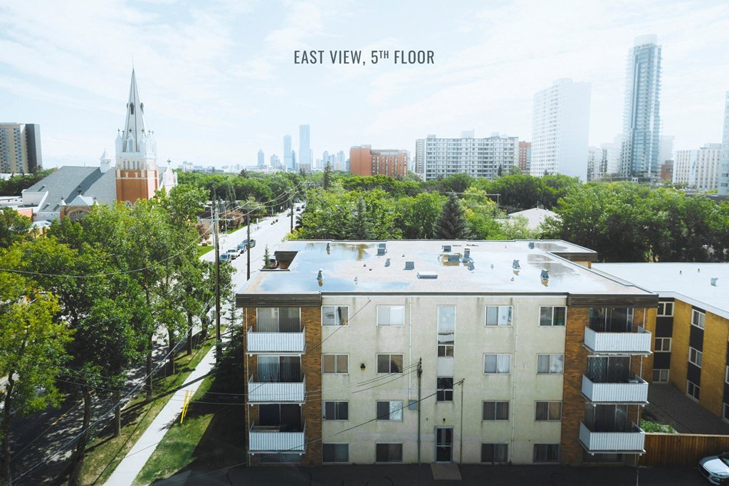 an aerial view of a building with a city in the background