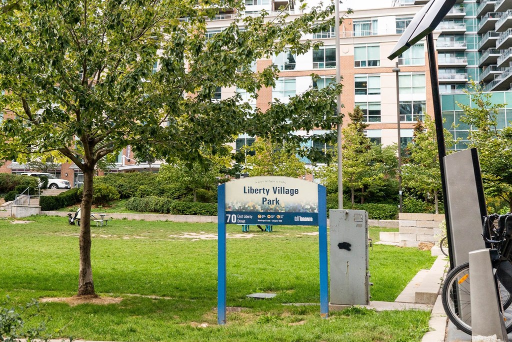 a sign in a park in front of a building