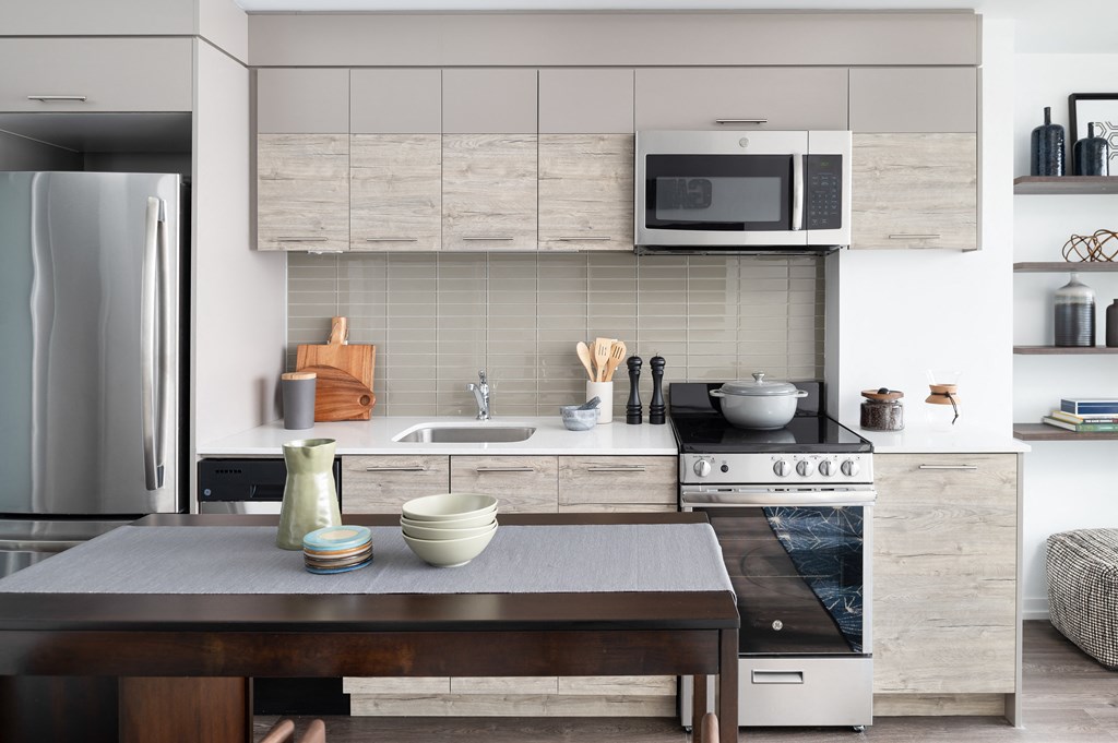 a kitchen with white cabinets and a wooden table