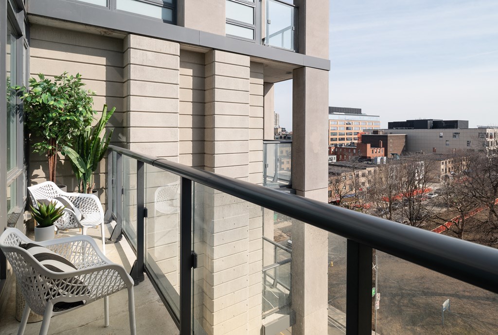 a balcony with chairs and a view of the city