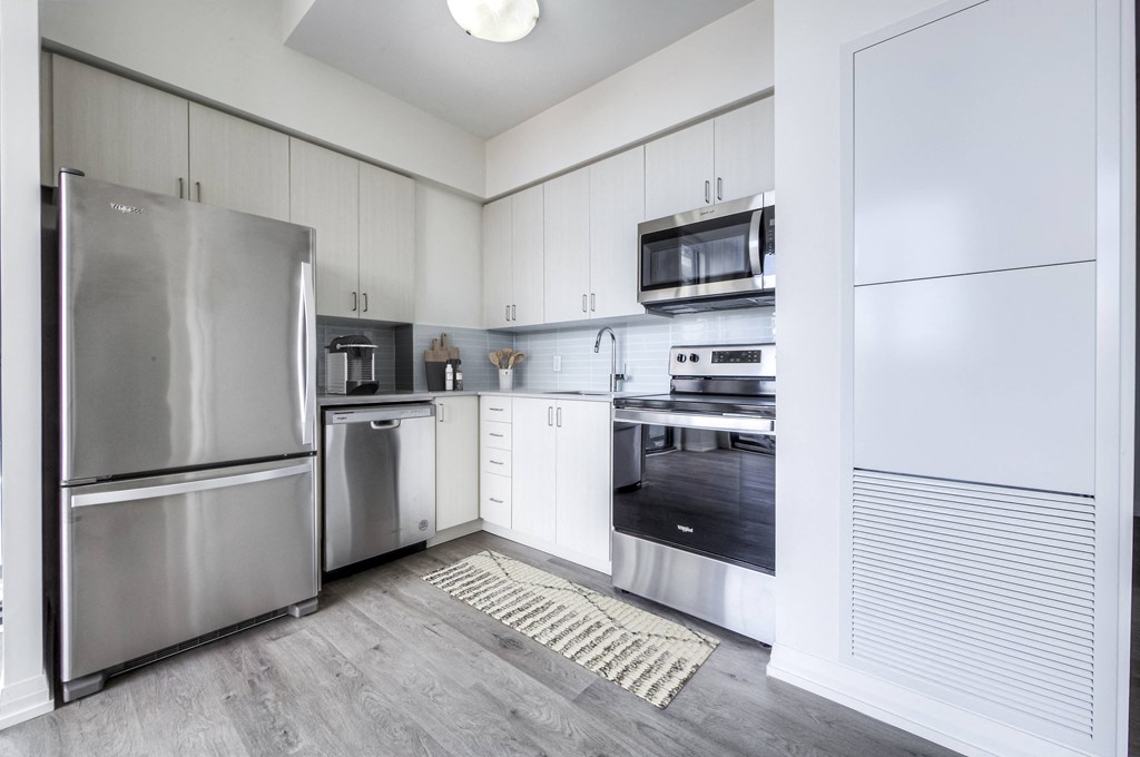 a kitchen with stainless steel appliances and white cabinets