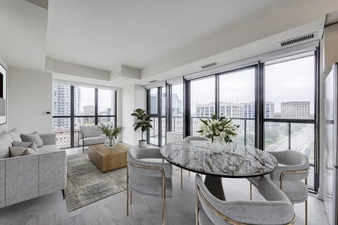 a living room with a table and chairs and a view of the city