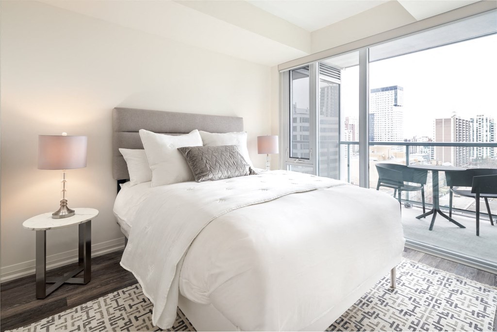 Suites- a bedroom with a large bed and a large window