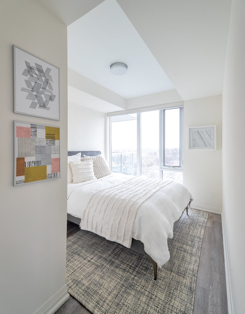 a bedroom with a bed and a large window