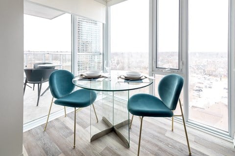 a dining room with a glass table and chairs