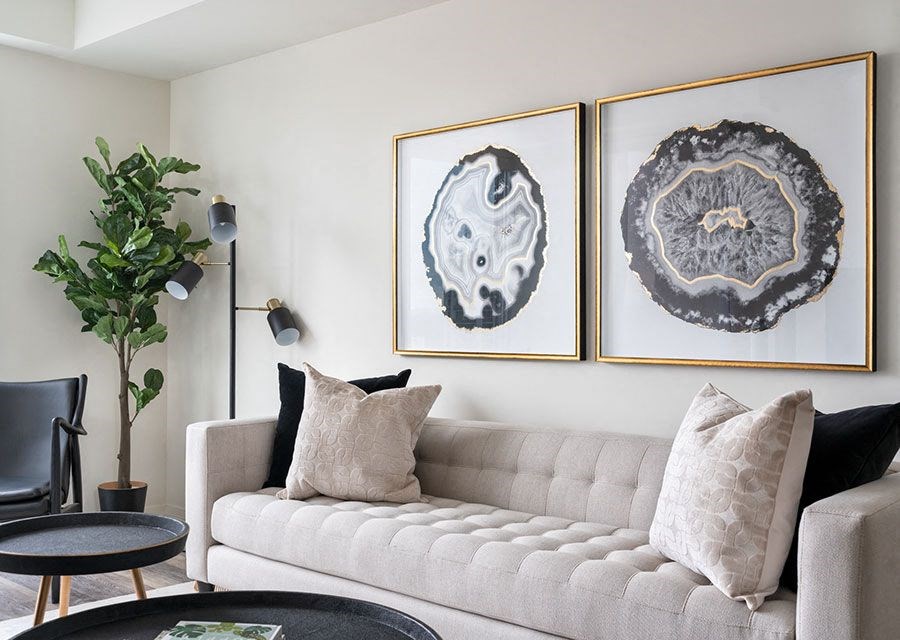 a living room with a couch and two paintings on the wall