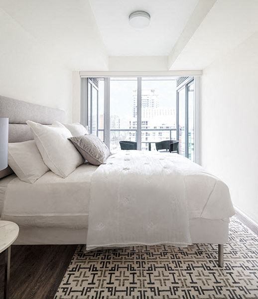 a white bedroom with a large bed and a window
