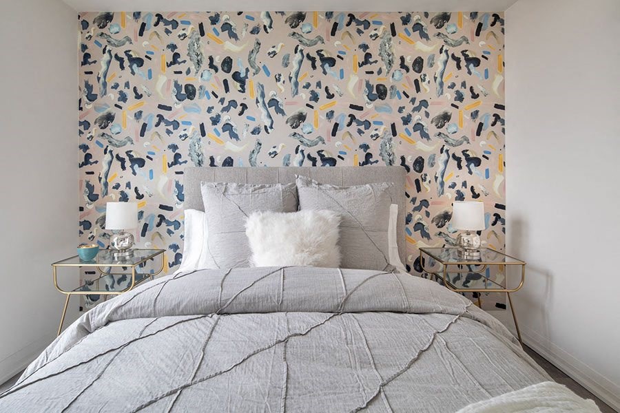 a bedroom with a bed and a wallpaper on the wall
