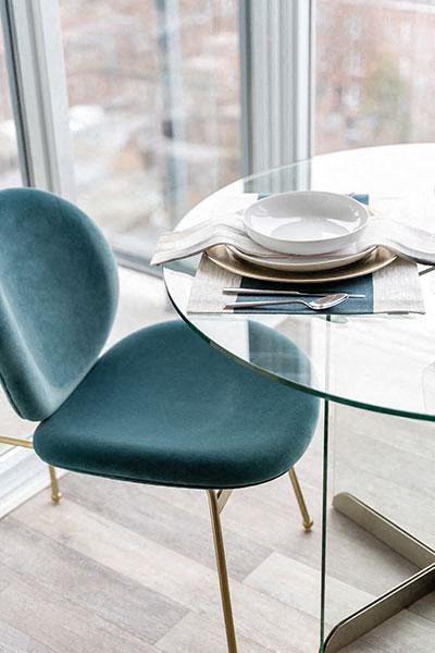 a table with a blue chair and a glass table