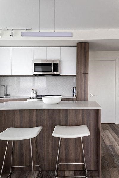 a kitchen with two stools and a sink and a microwave