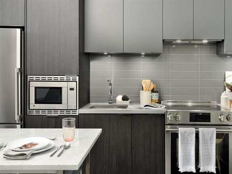 A modern kitchen with a table set for two.