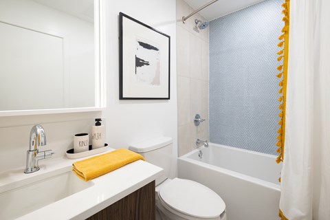 A white toilet sits next to a white sink in a bathroom.