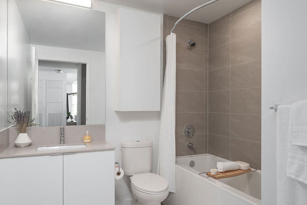 A white bathroom with a toilet, sink, and bathtub.