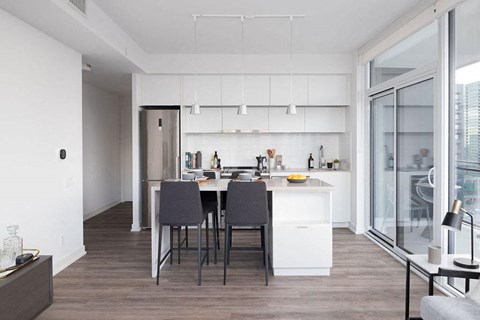 A modern kitchen with a dining table and chairs.