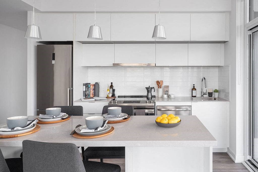 A modern kitchen with a dining table set for two.