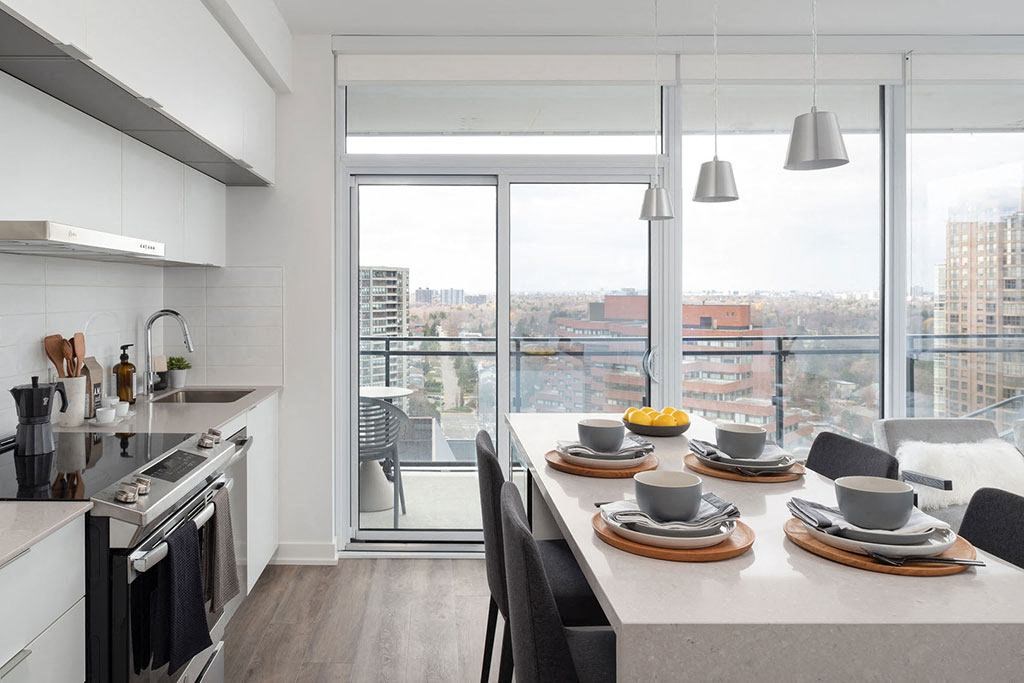 A modern kitchen with a dining table set for two.