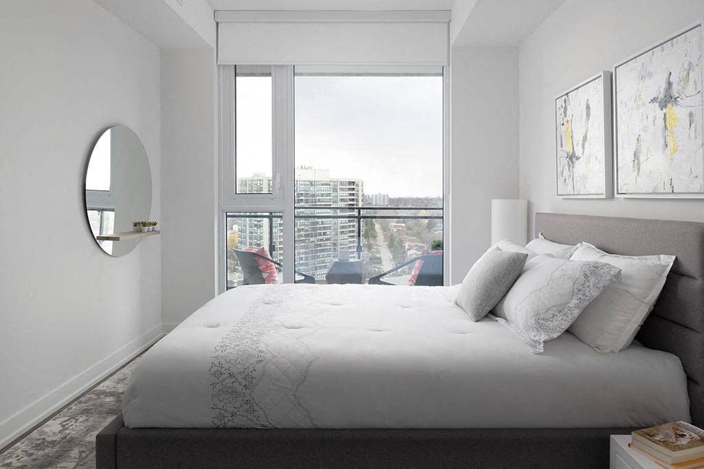 A bedroom with a large bed and a view of the city.