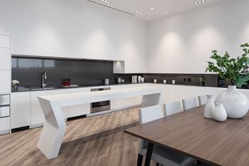 A modern kitchen with a wooden table and white chairs.